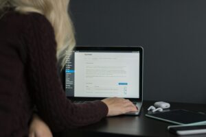 femme en pull noir utilisant un MacBook Pro