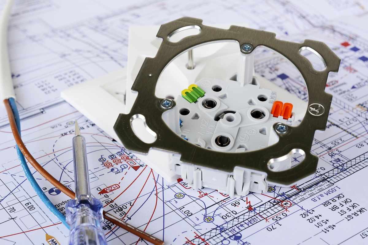 Un interrupteur ouvert avec câbles et tournevis sur un plan technique