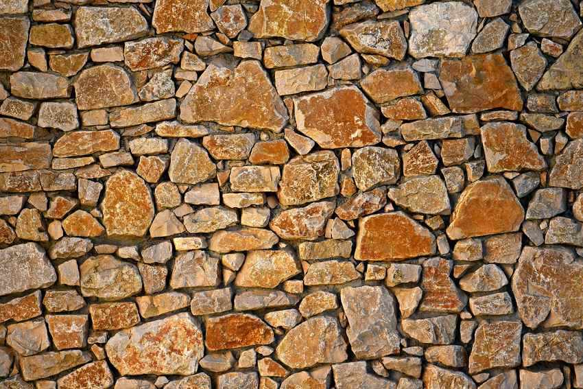 Mur de pierres de différentes tailles et formes, sans mortier visible