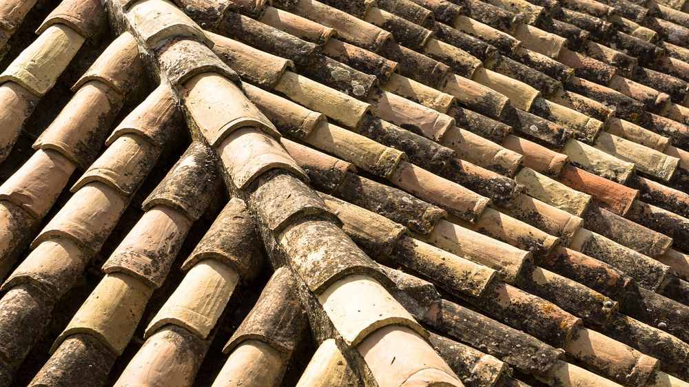 Tuiles de terre cuite formant un toit incliné légèrement usées